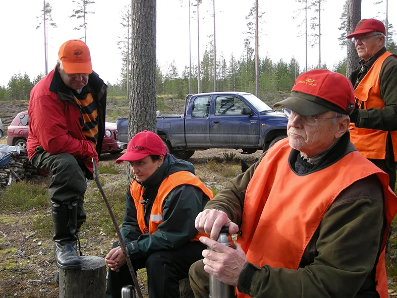 Seuran jäseniä yhteisellä tauolla metsässä
